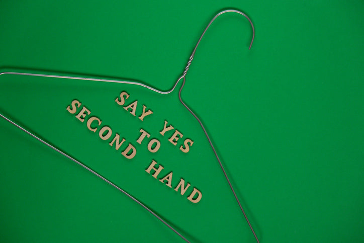 un cintre sur fond vers accompagné du texte Say yes  to second hand