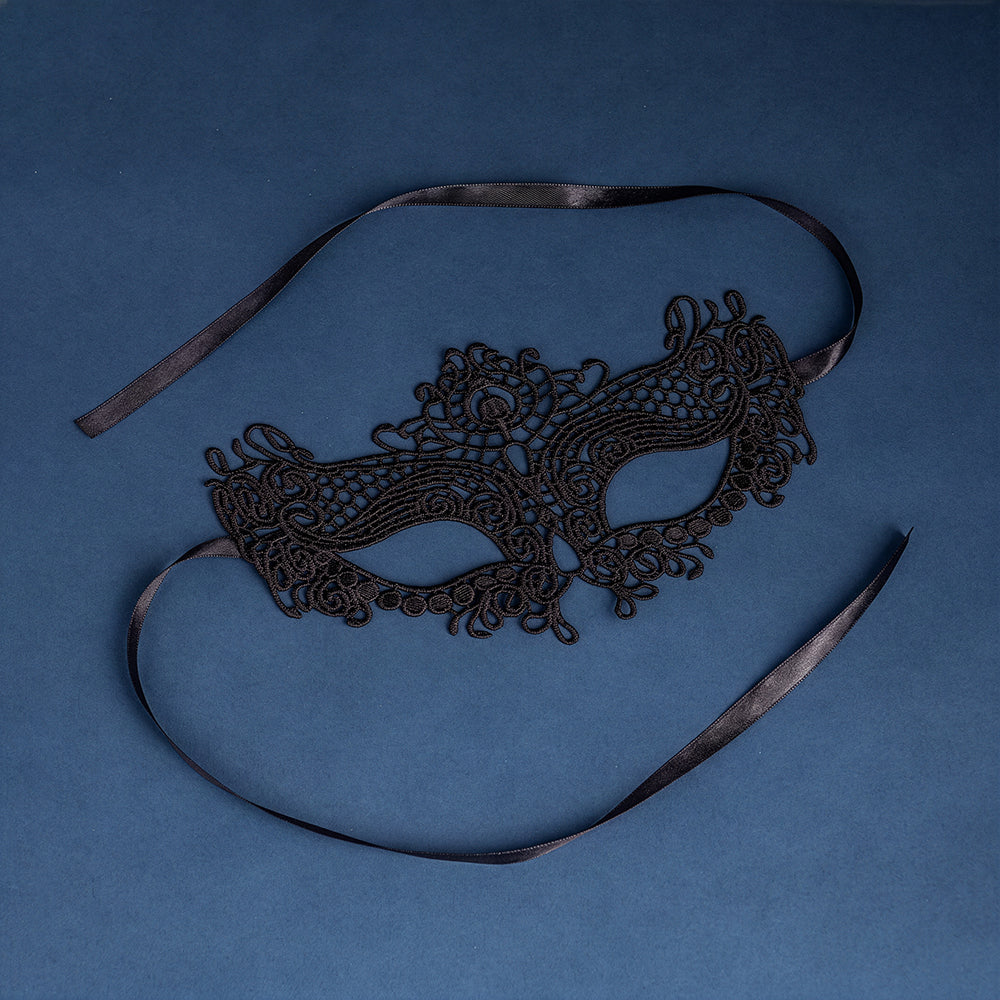 Eine schwarze Spitzenmaske mit einem Band auf blauem Hintergrund